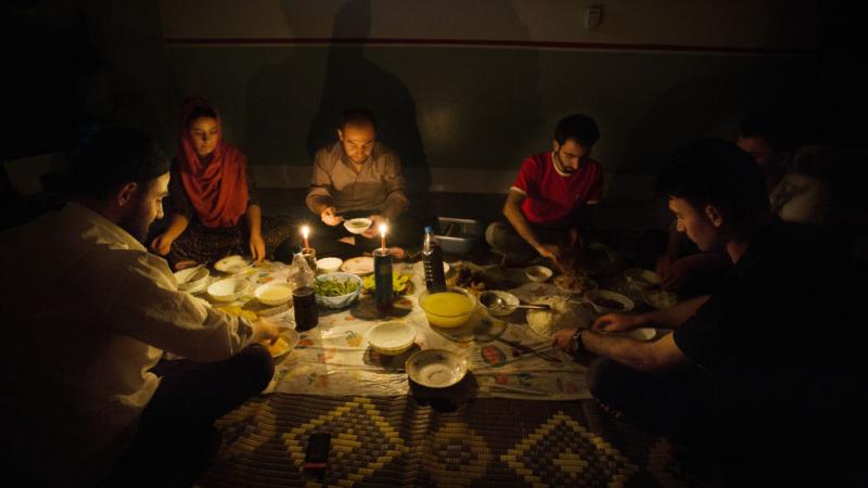 عراقيون يتناولون طعام الإفطار على ضوء الشموع. 