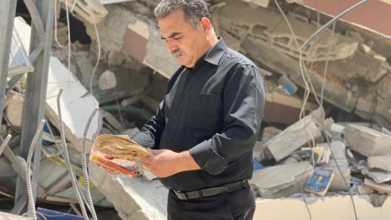 سمير منصور أمام مكتبته التي دمرها العدوان الاسرائيلي على غزة.