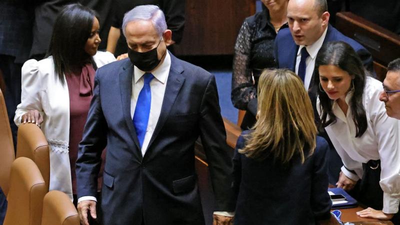 رئيس الوزراء الإسرائيلي المنتهية ولايته بنيامين نتنياهو يمشي أمام خليفته نفتالي بينيت (غيتي)