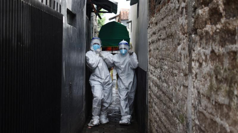 موظفو الصحة ينقلون جثة رجل مات بسبب فيروس كورونا من منزله في باندونغ