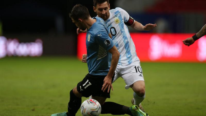 ميسي ممارساً هوايته في اختراق دفاع الخصم خلال المباراة مع أوروغواي (غيتي)