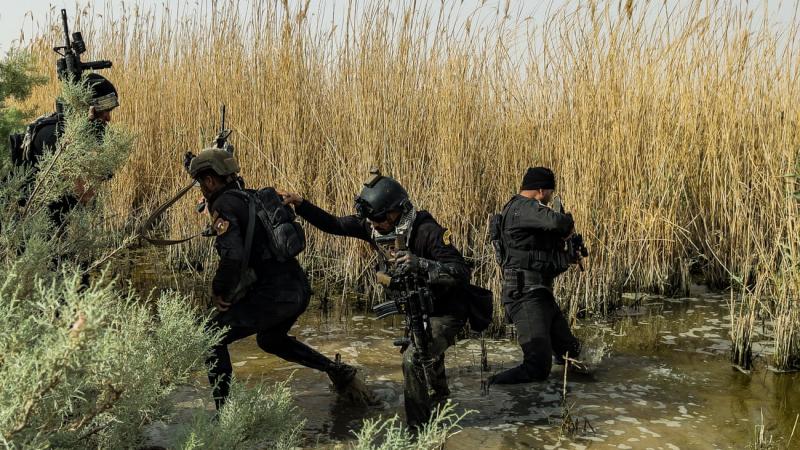سار عناصر القوات الخاصّة العراقية عبر الماء والطين بحثًا عن العدو المراوغ الذي هرب بعيدًا