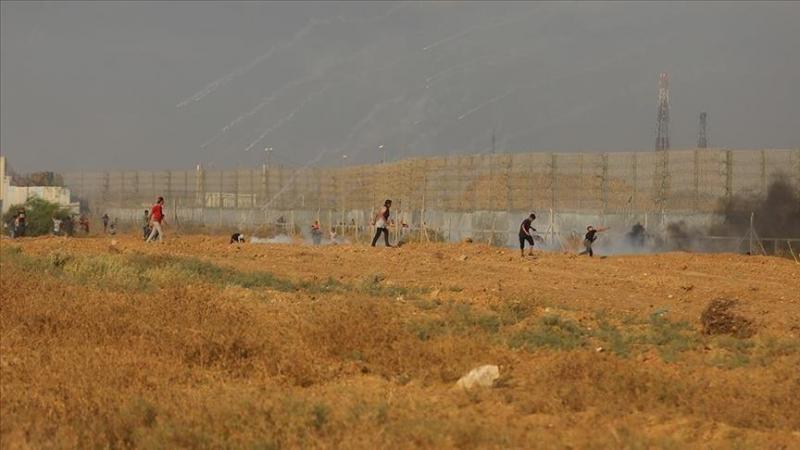 أطلق عدد من المتظاهرين قنابل صوتية باتجاه عدد من الدبابات الإسرائيلية المتمركزة خلف تلال رملية (الأناضول)
