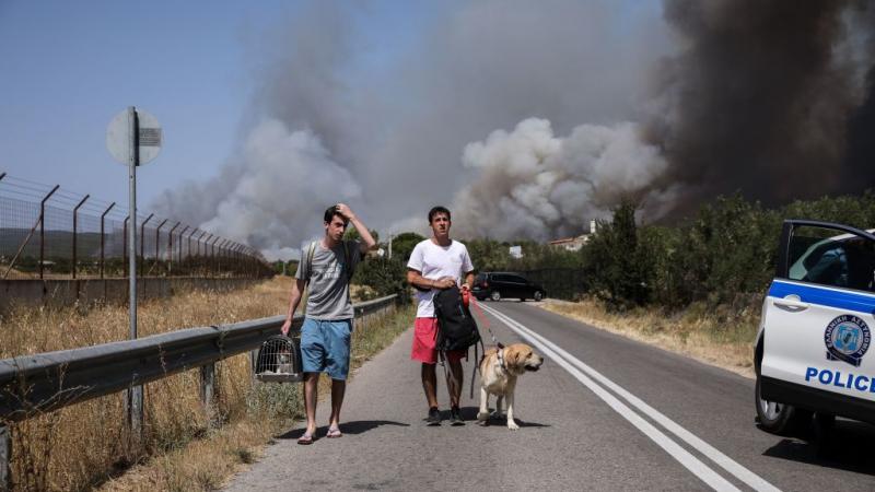 السكان المحليون يبتعدون عن منطقة فاريمبوبي حيث اندلع حريق غابات جديد شمال أثينا 