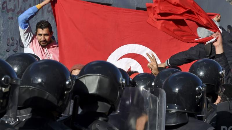 متظاهرون تونسيون يواجهون عناصر الشرطة خلال مظاهرة في تونس
