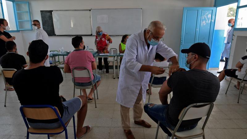 مسعفون تونسيون يقدمون  اللقاح ضد كورونا في أحد مراكز التلقيح بتونس العاصمة (غيتي)