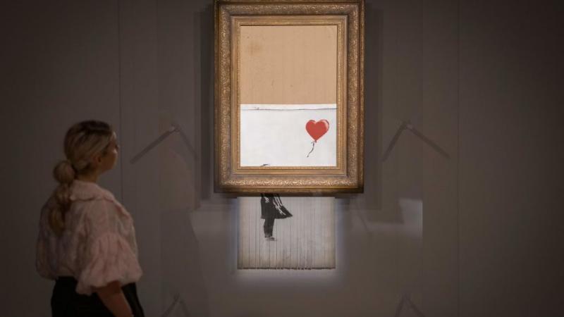 بيعت نسخة جديدة من لوحة بانكسي الشهيرة "الحب في سلة المهملات" مقابل 25.4 مليون دولار (غيتي)