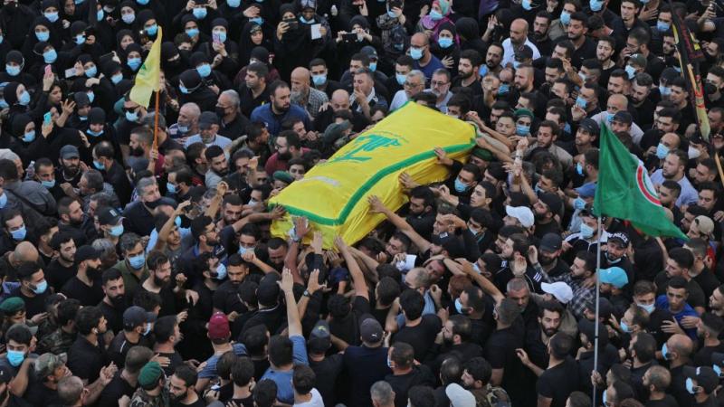 لُفّت الجثامين براية حزب الله الصفراء اللون، وأحاط بها عناصر من الحزب بلباس عسكري (غيتي)