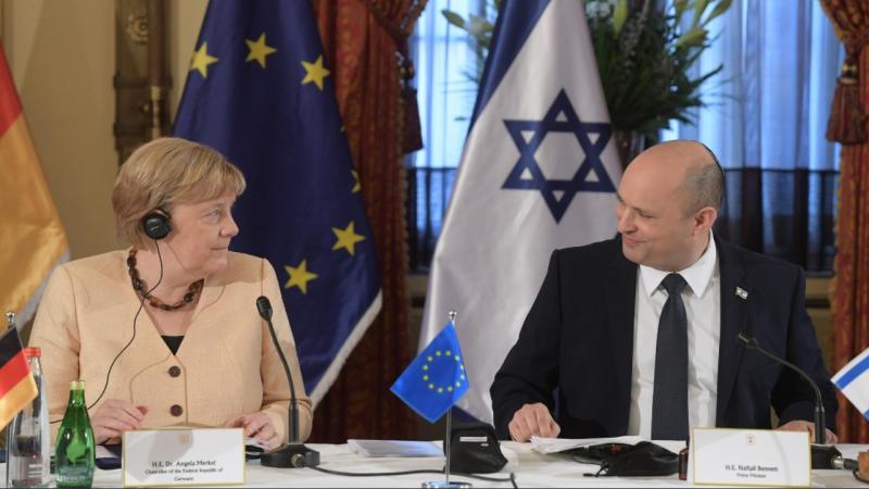 رئيس وزراء الاحتلال الإسرائيلي نفتالي بينيت والمستشارة الألمانية أنغيلا ميركل (غيتي)