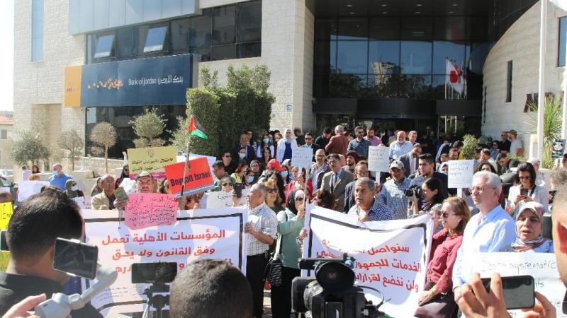 رفع المشاركون لافتات تُدين القرار الإسرائيلي وأُخرى تُطالب بتوفير الحماية للمؤسسات الفلسطينية (وكالة وفا الفلسطينية)
