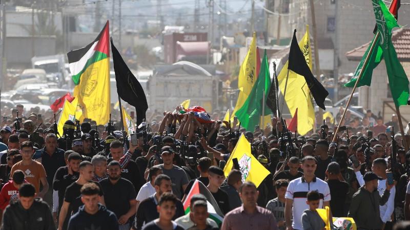 رفع المشاركون في الجنازة العلم الفلسطيني ورايات فصائل فلسطينية 
