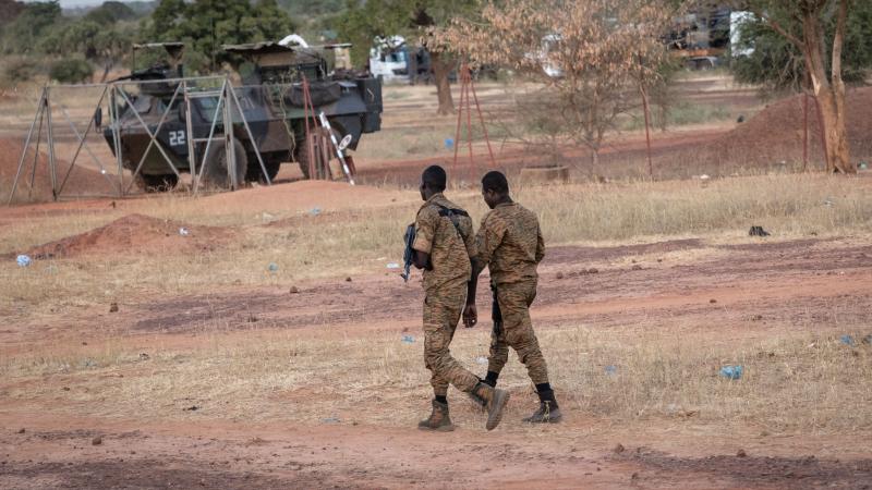 ضباط من جيش بوركينا فاسو يقومون بدورية بالقرب من عربة مدرعة فرنسية متوقفة في كايا (غيتي)