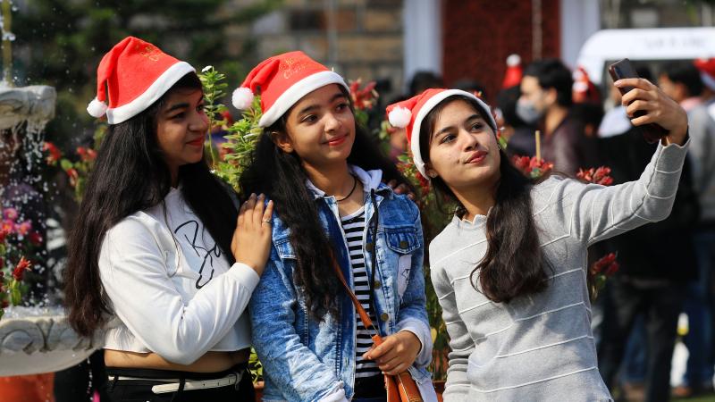 فتيات يلتقطن صورة سيلفي في كنيسة القديس أندرو خلال احتفالات عيد الميلاد بالهند (غيتي)
