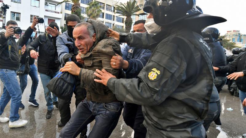 اعتقال رجل تونسي خلال احتجاجات ضد الرئيس قيس سعيد بذكرى الثورة التونسية (غيتي)