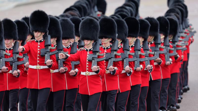 يرتدي عناصر أفواج النخبة في الجيش قبعات "بير سكينز" أثناء تغيير الحرس أمام قصر باكنغهام 