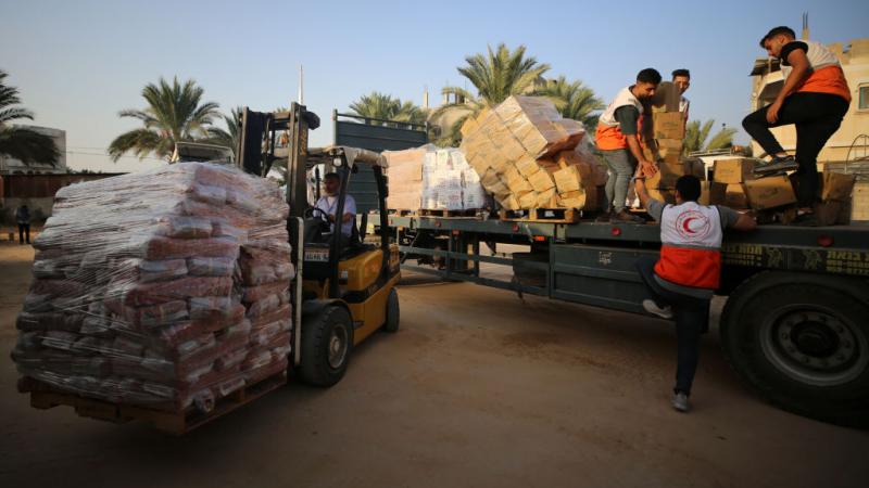 عمال الهلال الأحمر الفلسطيني يقومون بفرز المساعدات قبل توزيعها على الفلسطينيين في قطاع غزة