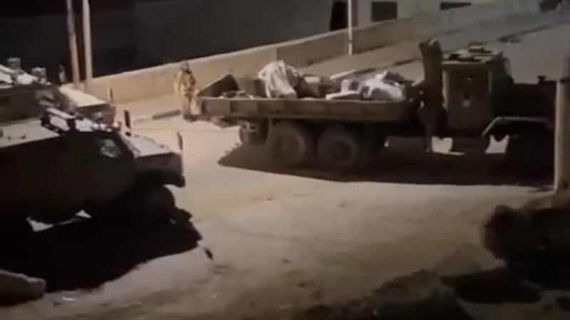 شاحنة تابعة لجيش الاحتلال تنقل الأجهزة المصادرة من جمعية الأيتام في الخليل